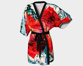 Puede incluir: Una bata de kimono de estampado abstracto rojo, azul y blanco con una cinta negra.