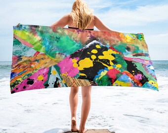 May include: A colourful beach towel featuring abstract shapes and paint splatters in shades of pink, yellow, green, blue and black. The towel is made from soft, absorbent material and is ideal for drying off after a swim.