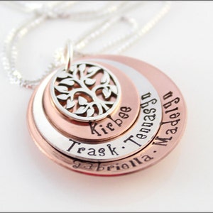 May include: A silver necklace with a tree of life pendant and four circular discs with the names "Gabrielle", "Trask", "Kirbee", "Tennasen", and "Madelyn" engraved on them.