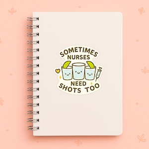 K&ouml;nnte beinhalten: Ein wei&szlig;es Spiralnotizbuch mit einem Aufkleber mit der Aufschrift "Sometimes Nurses Need Shots Too". Der Aufkleber zeigt drei Cartoon-Schnapsgl&auml;ser mit Limettenspalten, eine Spritze und ein Herz. Der Hintergrund ist hellrosa.