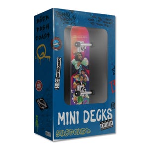 Puede incluir: Un mini monopatín en una caja azul. El monopatín tiene un diseño colorido con un retrato de una persona. La caja tiene las palabras "MINI DECKS" y "SK8BOARD" impresas. La caja también tiene arte estilo grafiti y el texto "PARENTAL ADVISORY EXPLICIT CONTENT".