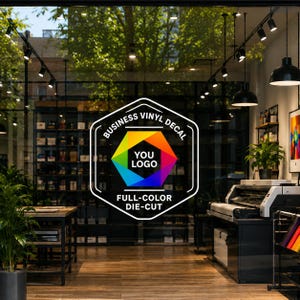 Op de afbeelding: Een zeshoekige zakelijke vinylsticker aangebracht op een glazen raam. Het ontwerp heeft een witte omlijning, de tekst BUSINESS VINYL DECAL en FULL-COLOR DIE-CUT, en een centrale veelkleurige geometrische vorm met de tekst YOU LOGO.