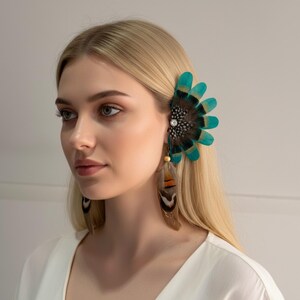 Puede incluir: Un brazalete de plumas de color turquesa y marrón y pendientes colgantes a juego. El brazalete presenta un grupo de plumas turquesas y un adorno central. Los pendientes tienen plumas marrones y naranjas con un acento de cuentas de madera.