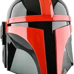 Pode incluir: Um capacete Mandaloriano preto e vermelho com acabamento brilhante. O capacete apresenta uma viseira vermelha proeminente e uma faixa vermelha central. O design &eacute; angular e futurista, com uma apar&ecirc;ncia elegante e polida.