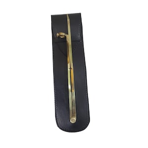 May include: A brass proportional divider in a black leather case. The divider is a golden color and has a screw adjustment. The case is rectangular and has a flap closure.