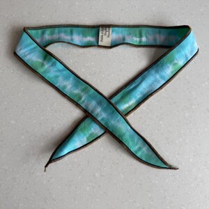 Może przedstawiać: Zestaw trzech ceramicznych kubk&oacute;w z nakrapianym, matowym wykończeniem. Kubki są w odcieniach kremu, jasnoszarym i ciemnoszarym. Każdy kubek ma prosty, minimalistyczny design i zaokrąglony uchwyt.