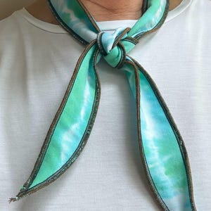 Może przedstawiać: Biały ceramiczny kubek z czarnym uchwytem i napisem "But First, Coffee" pogrubioną czcionką. Kubek stoi na drewnianej powierzchni. Kubek ma pojemność około 355 ml.