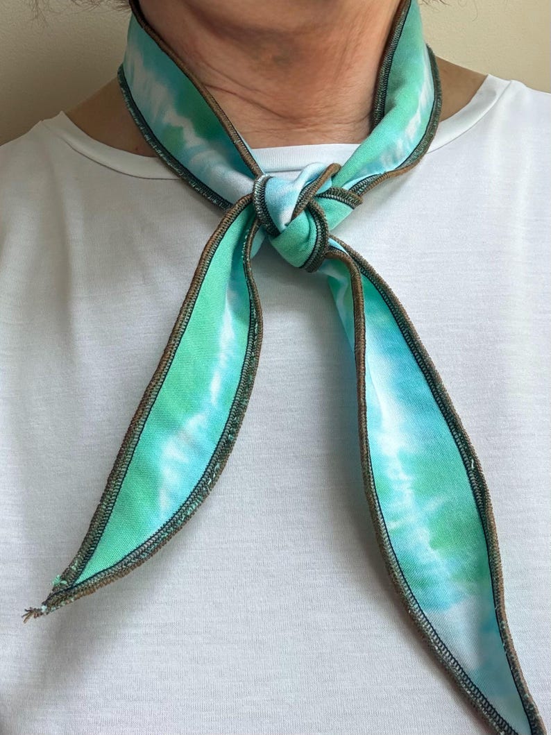 Może przedstawiać: Biały ceramiczny kubek z czarnym uchwytem i napisem "But First, Coffee" pogrubioną czcionką. Kubek stoi na drewnianej powierzchni. Kubek ma pojemność około 355 ml.