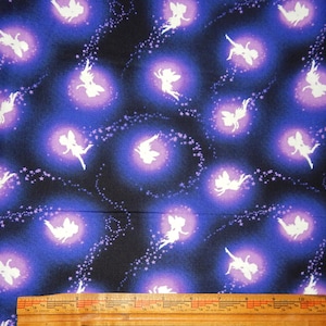 May include: Fabric with a repeating pattern of white fairy silhouettes within glowing purple and blue orbs against a dark blue background. The design includes swirling star trails, creating a whimsical, fantasy theme.