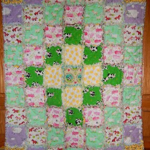May include: A handmade patchwork quilt featuring a farm animal theme. The quilt is composed of numerous squares in various colors, including green, yellow, and purple. Each square showcases different farm animals like cows, pigs, and horses. The edges have a frayed, textured finish.