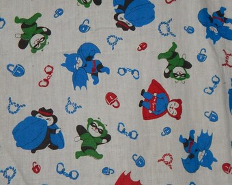 May include: White fabric with a repeating pattern of cartoon superheroes in various poses. The superheroes are wearing blue, red, green, and black costumes. There are also chains and padlocks in the pattern.