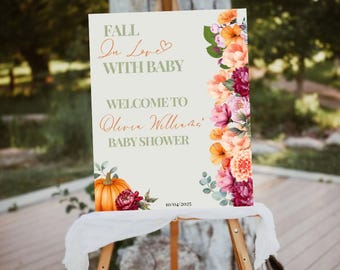 Könnte beinhalten: Ein Willkommensschild für eine Babyparty auf einer Staffelei. Auf dem Schild steht "Fall in Love with Baby" und "Welcome to Olivia Williams' Baby Shower". Es zeigt florale und Kürbis-Akzente in Orange, Rosa und Burgunderrot. Das Datum 10.04.2023 ist unten aufgedruckt.