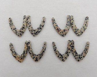 May include: Six dalmatian jasper stone V-shaped pendant charms. The charms are a light beige color with black and orange spots.