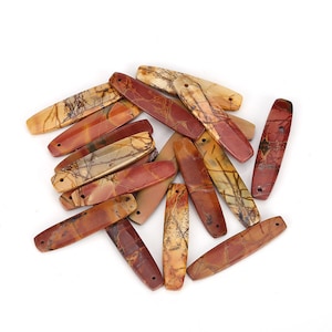 May include: A pile of brown, red, and beige stone beads with a marbled pattern. The beads are oval shaped and have two holes drilled through them.