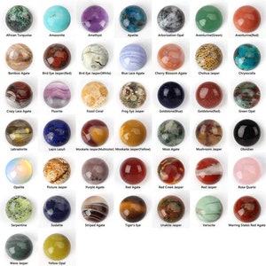 Puede incluir: Surtido de 36 piedras preciosas redondas en cabujón, cada una con un color y un patrón únicos. Las piedras están dispuestas en una cuadrícula, con cada piedra etiquetada con su nombre. Las piedras incluyen amatista, ágata, aventurina, crisocola, jaspe, labradorita, ópalo, cuarzo, serpentina, sodalita, ojo de tigre, y más.