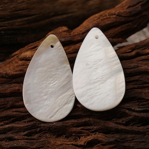 Pingente de madrepérola natural em formato de gota, branco, para confecção de brincos e colares, ideal para presente. Dimensões: 28x17x3mm. 5g-Q395
