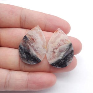 Pode incluir: Uma caneca de cerâmica branca com uma alça preta e o texto "But First, Coffee" em estilo manuscrito. A caneca está sobre uma superfície branca. A caneca tem aproximadamente 10 cm de altura.