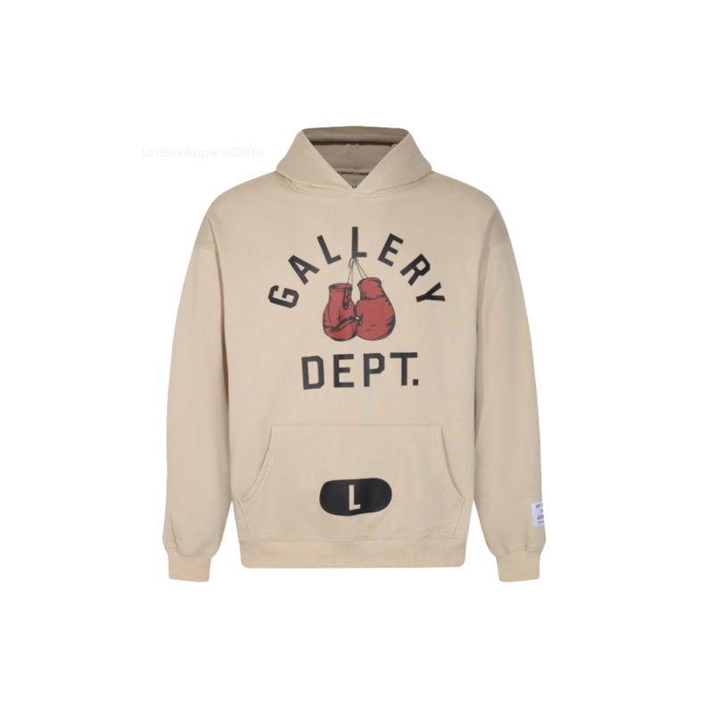 May include: A beige hoodie with a front pocket and a hood. The front of the hoodie features the text "GALLERY DEPT." above a graphic of red boxing gloves. A black "L" is on the front pocket. The hoodie has a relaxed fit.