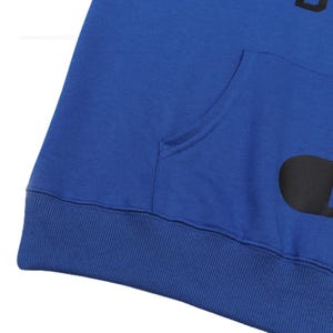 May include: Royal blue hoodie with a kangaroo pocket and a black graphic. The hoodie features a ribbed hem and cuffs. The text on the hoodie is partially visible. The hoodie is made of a soft material.