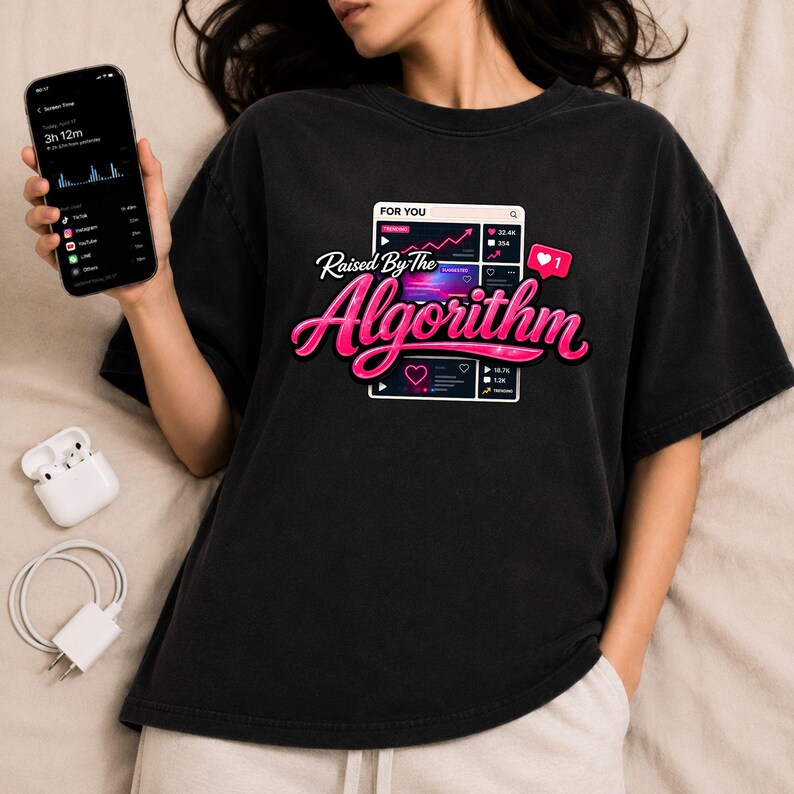 Lifestyle mockup featuring Raised By The Algorithm shirt design with smartphone and internet culture aesthetic.