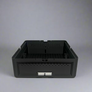 May include: A black plastic storage crate with a rectangular shape. The crate has a perforated design on the sides and a label with the number "2". The crate is empty and sits against a gray background.