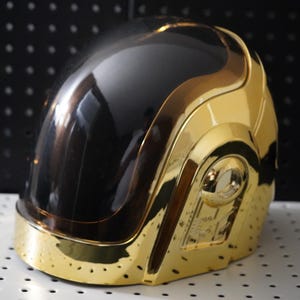 Cosplay do capacete dourado do Daft Punk, réplica do capacete cromado dourado transparente do Guy-Manuel.