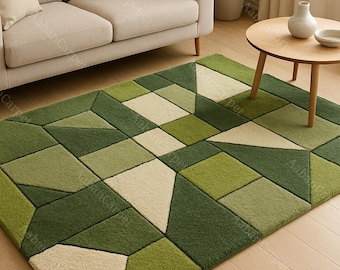 May include: Geometric patterned area rug in shades of green and cream. The rug features a modern design with various geometric shapes. The rug is placed on a wooden floor, with a beige sofa and a small wooden table in the background.