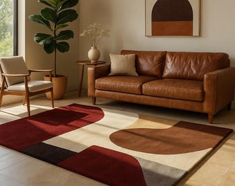 Könnte beinhalten: Ein modernes Wohnzimmer mit einem braunen Ledersofa, einem Teppich mit geometrischen Mustern in Rot-, Braun- und Beigetönen und einem gerahmten abstrakten Kunstwerk. Eine Topfpflanze und ein Holzstuhl ergänzen die Einrichtung.