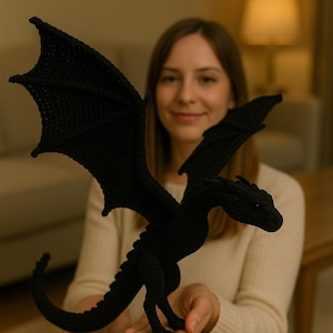 May include: A black crochet dragon with outstretched wings. The dragon has a long tail and detailed features. The wings are large and spread out. The dragon is a handmade item, perfect for fantasy enthusiasts.