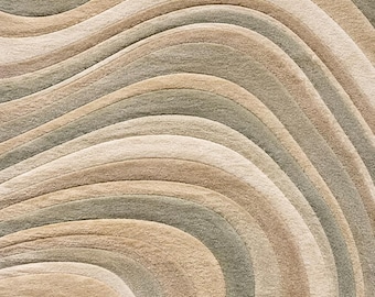 May include: A textured area rug featuring a repeating pattern of flowing, organic waves in shades of sage green, cream, and warm beige. The design consists of carved, multi-layered lines that create a sense of depth and movement across the surface.