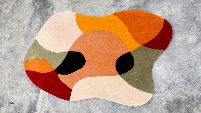 Large Hand Tufted Rug – Contemporary Rust Beige Abstract Design Carpet
Modern Luxury Rug – Rust, Beige & Red Hand Tufted Home Decor Rug. abstract rug with a freeform shape. The rug features a pattern of overlapping shapes in various colors, including orange, red, black, beige, and green. The rug is designed to be a decorative floor covering.