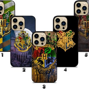 May include: A collection of phone cases featuring the Hogwarts crest. The cases display the crest in various designs, including a wooden texture, a black background, and a navy blue background with a moon. Each case has a different color scheme.