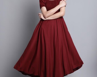 May include: A burgundy-colored dress with a square neckline and short sleeves. The bodice has a textured design, and the skirt flares out. The dress is knee-length and suitable for various occasions.