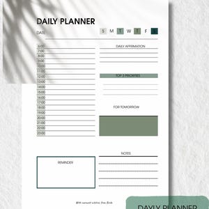 May include: A white daily planner with a minimalist design. The planner includes sections for time slots, daily affirmations, top priorities, reminders, and notes. The text "DAILY PLANNER" is at the top, with "DAYLY PLANNER" at the bottom.