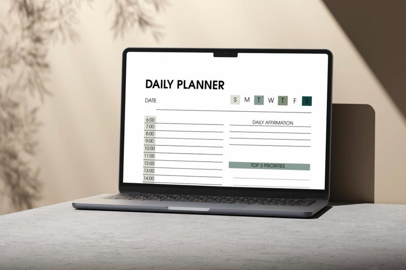 May include: A laptop displaying a digital daily planner. The screen shows a white background with the words "DAILY PLANNER" at the top. The planner includes sections for the date, daily affirmations, and top 3 priorities.