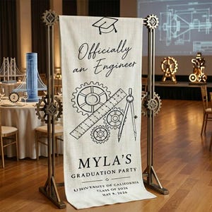 Peut inclure: Une bannière de fête de remise de diplôme avec le texte "Officiellement ingénieur" et "Fête de remise de diplôme de Myla". La bannière présente des graphiques sur le thème de l'ingénierie, notamment des engrenages, une règle et un compas. La bannière est soutenue par un cadre métallique avec des engrenages décoratifs.