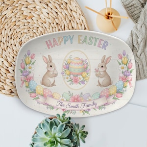 May include: An oval Easter serving platter with a pastel design. The platter features the text "HAPPY EASTER" and "The Smith Family". It includes illustrations of bunnies, Easter eggs, and flowers. The background has a wood grain appearance.
