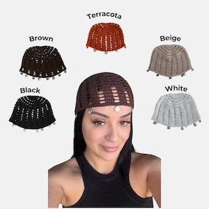May include: A collection of five crochet skull caps featuring a repeating vertical stitch pattern and small circular metallic charms along the bottom edge. The caps are available in brown, terracotta, beige, black, and white color variations.