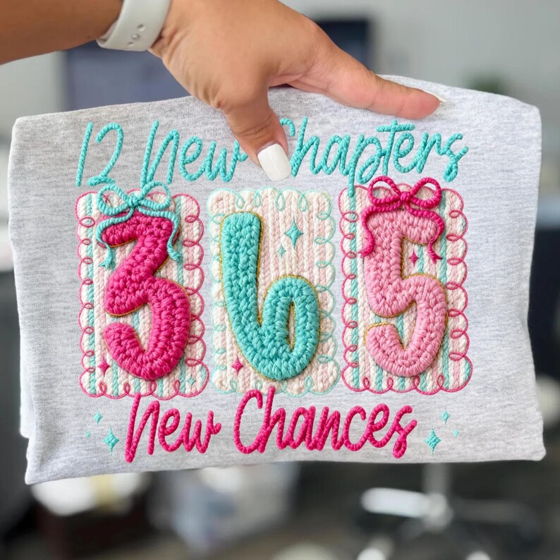 Puede incluir: Camiseta gris con el texto bordado "12 New Chapters 365 New Chances". Los n&uacute;meros 3, 6 y 5 est&aacute;n en crochet rosa y turquesa. El dise&ntilde;o incluye lazos y bordes decorativos.