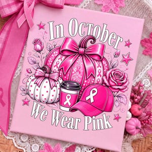 May include: A square pink sign featuring the text In October We Wear Pink, a large pink pumpkin with ribbon patterns, a smaller white pumpkin with pink dots, a pink coffee cup, a pink baseball cap, and pink roses, all accented with pink stars.
