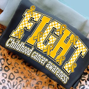 May include: A black t-shirt featuring the word FIGHT in large, yellow, checkered block letters. Multiple yellow awareness ribbons are integrated into the design. Below the main text, the words Childhood cancer awareness are printed in white.