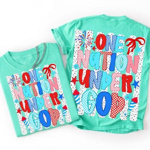 Pu&ograve; includere: Due t-shirt verde menta con una stampa grafica con il testo ONE NATION UNDER GOD. Il design include motivi rossi, bianchi e blu, stelle, fuochi d'artificio e un fiocco rosso su uno sfondo di strisce verticali a pois neri.