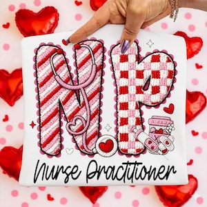 May include: White t-shirt with the letters "NP" in red and pink embroidery, featuring a stethoscope and medical-themed graphics. The words "Nurse Practitioner" are written in black script below the letters.