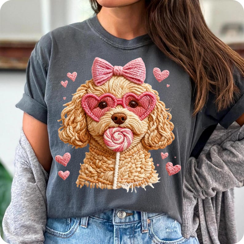 May include: Dark gray t-shirt featuring a cartoon poodle with heart-shaped sunglasses, a pink bow, and a lollipop. Pink hearts surround the poodle. The shirt has rolled-up sleeves and a casual fit.