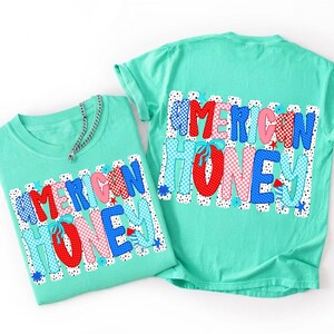 May include: Two mint green t-shirts featuring the text AMERICAN HONEY in a bold, multi-patterned font. The letters incorporate red, white, and blue colors with polka dot, checkered, and striped designs, accented by small blue flowers and stars.