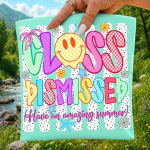 May include: A light mint green fabric square featuring the text "CLASS DISMISSED" in colorful, checkered, bubble-style letters. A yellow smiley face, pink bow, small flowers, stars, and the text "Have an amazing summer" are printed on it.