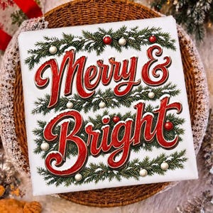 Może przedstawiać: Kwadratowa biała tabliczka z czerwonym napisem Merry & Bright wykonanym kursywą. Tekst otaczają ilustracje zielonych gałązek sosnowych opr&oacute;szonych białym śniegiem, ozdobione małymi czerwonymi i białymi kulistymi bombkami świątecznymi.