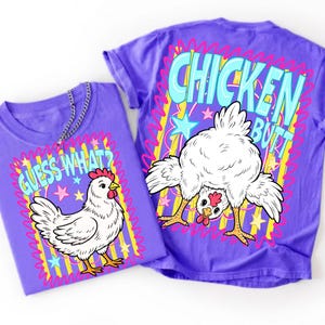 Op de afbeelding: Een paars t-shirt met een witte kipafbeelding en de tekst "GUESS WHAT?" op de voorkant, en een grotere afbeelding van een kip met de tekst "CHICKEN BUTT" op de achterkant, beide omringd door gele strepen, roze krabbels en sterren.