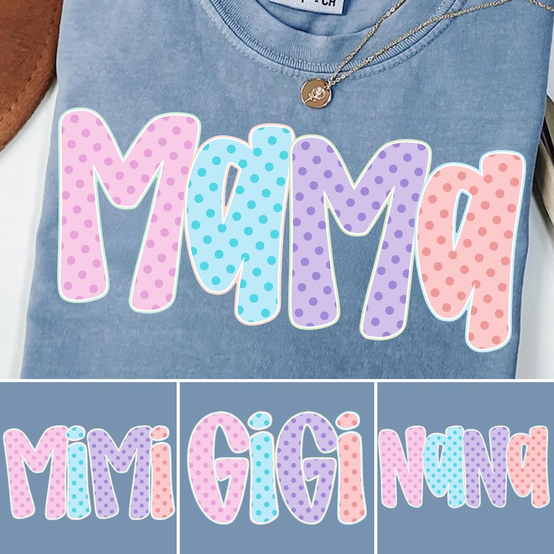 Puede incluir: Una camiseta azul con la palabra "Mama" en letras grandes y coloridas con lunares. Las letras est&aacute;n delineadas en blanco y rellenas con lunares rosas, azules y morados. Se ve un collar dorado con un colgante.