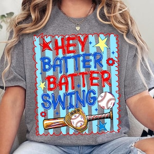 Może przedstawiać: Szary melanżowy t-shirt z grafiką zawierającą napis HEY BATTER BATTER SWING w kolorze czerwonym i niebieskim. Wz&oacute;r przedstawia piłkę do baseballu, drewniany kij, rękawicę baseballową, gwiazdki i kwiaty na tle jasnoniebieskich pionowych pas&oacute;w.